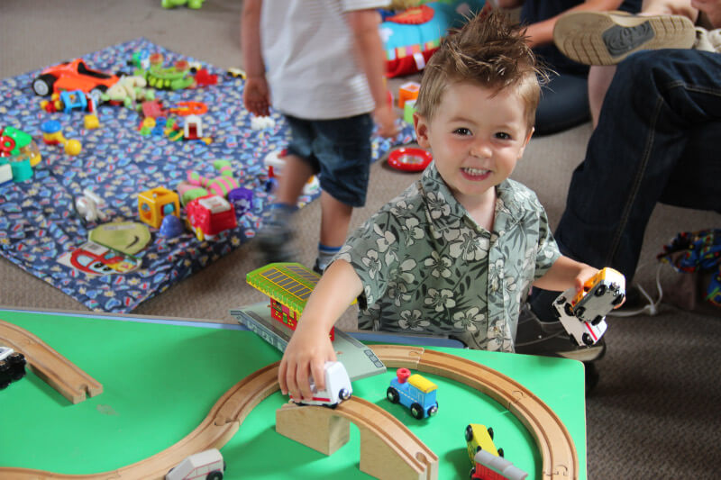 A young child playing with a train set.